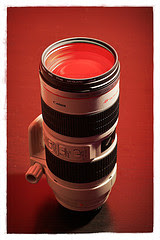 The Canon EF 70-200mm lens on a red background