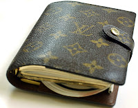 a brown leather wallet with gold designs