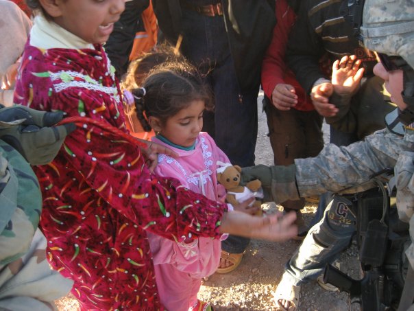 [Kile_in_Iraq_giving_a_to_a_little_girl_Jan_07.jpg]