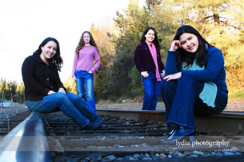 Friends sitting on the train tracks at lifestyle friends portraits in Colfax, California