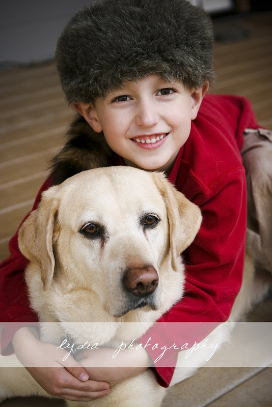 Little boy with a raccoon hat and a dog at lifestyle kids portraits at Grass Valley, California