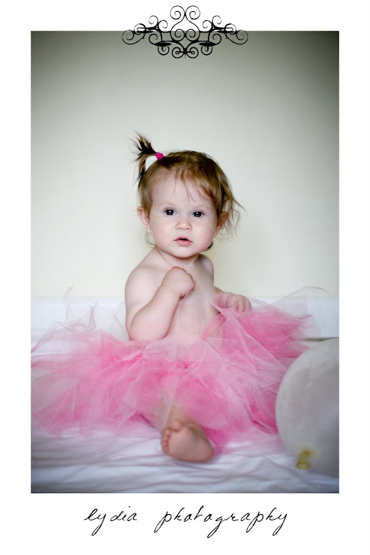 Baby on the bed with pink tutu at lifestyle baby portraits in Grass Valley, California