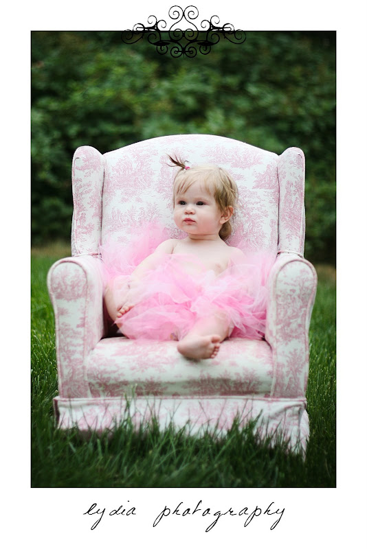 Baby sitting on a pink chair at lifestyle baby portraits in Grass Valley, California