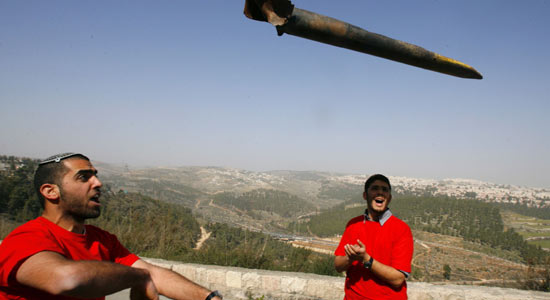 Israeli Protester throws remains of a Rocket