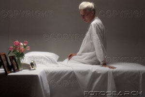 [senior-woman-sitting-on-bed+with+roses.jpg]