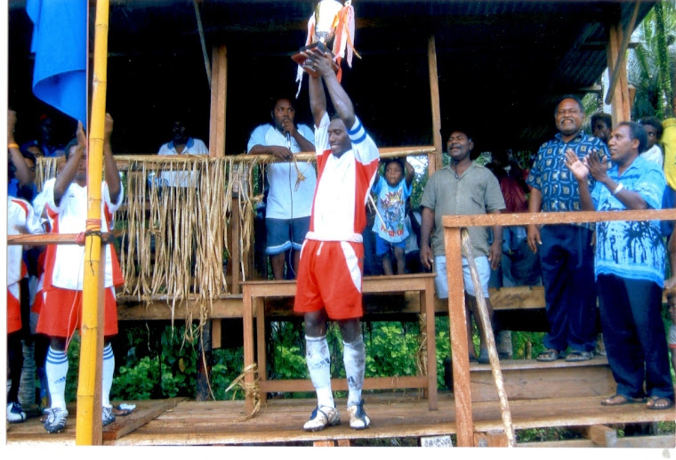 Santos FC Captain Mr. Augustine Rukarae hoisting high the trophy (1st Prize) won by Wairokai Club