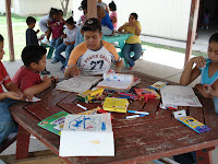 Some of the kids at the orphanage playing with coloring books and other gifts.