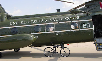 Image of folding bicycle next to Marines Corps helicopter
