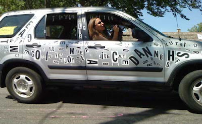 Silver car with magnetic poetry letters all over it