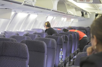 airplane interior with seats and flight attendants