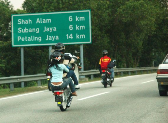 [motorcyclist+performing+a+wheelie+at+a+highway..jpg]