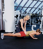 two women, one doing a plank exercise, the other one spotting her