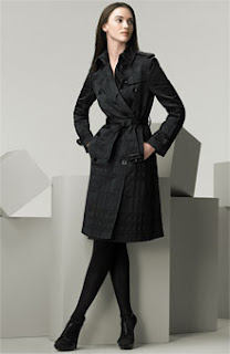 picture of woman standing with legs crossed wearing a black Burberry trench coat